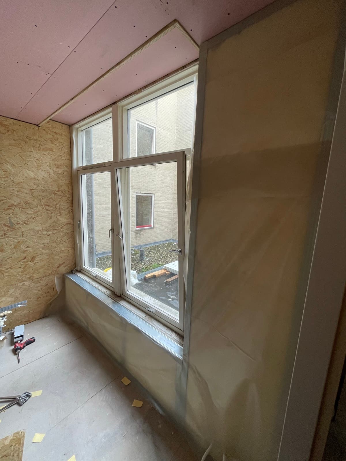 Geïsoleerde achtergevel in de slaapkamer, klaar voor afwerking